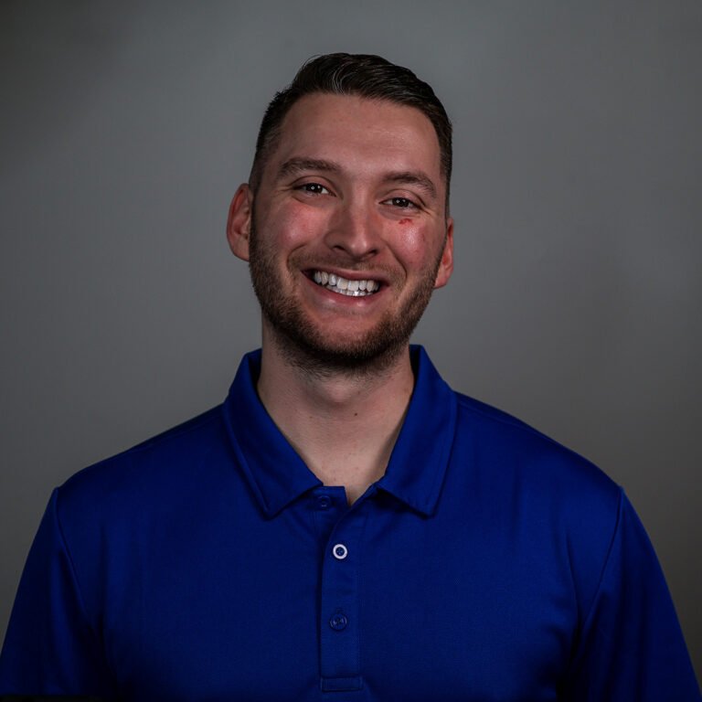 Headshot of Harley Downour, owner of Plumb & Level Marketing LLC. He is wearing a blue polo and smiling.